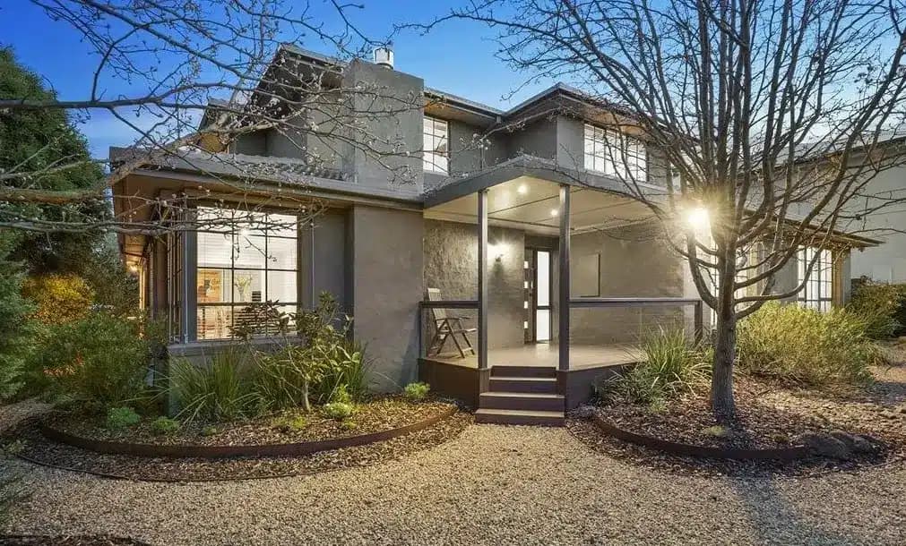 Two-storey home with an illuminated entrance and landscaped front garden