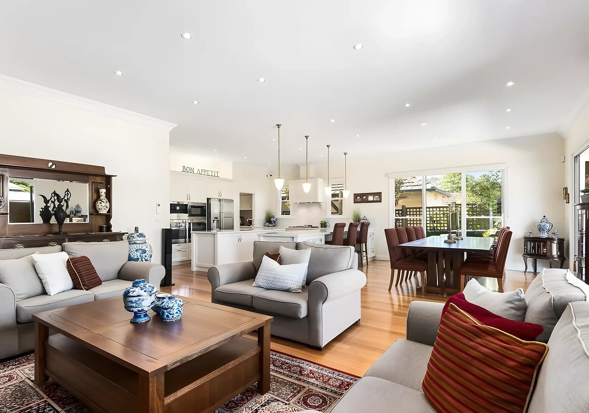 Open-plan living and dining room with pale sofas and timber furniture